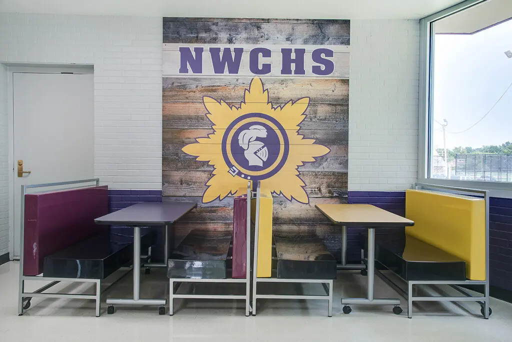 High School cafeteria fiberglass folding booths in school colors and mascot graphic behind the tables.
